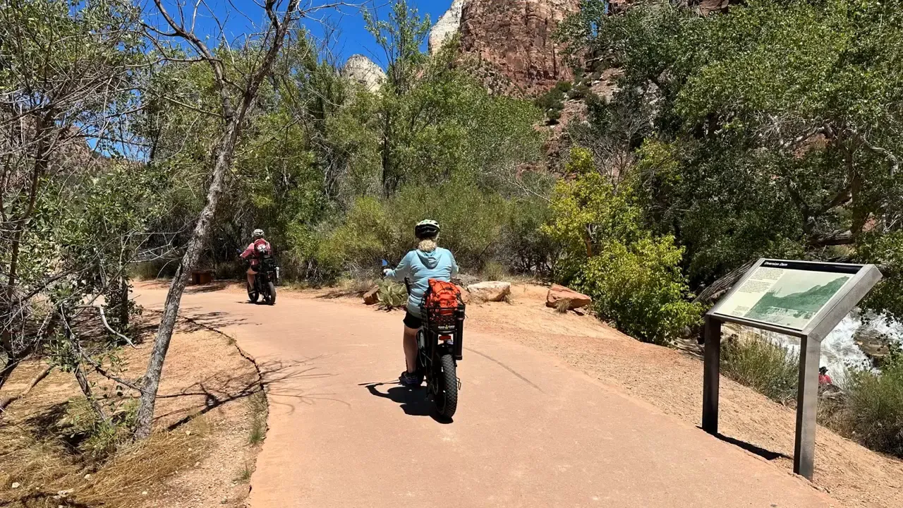 Cyclists riding along the Pa'Rus Trail with Zion's red cliffs in the background