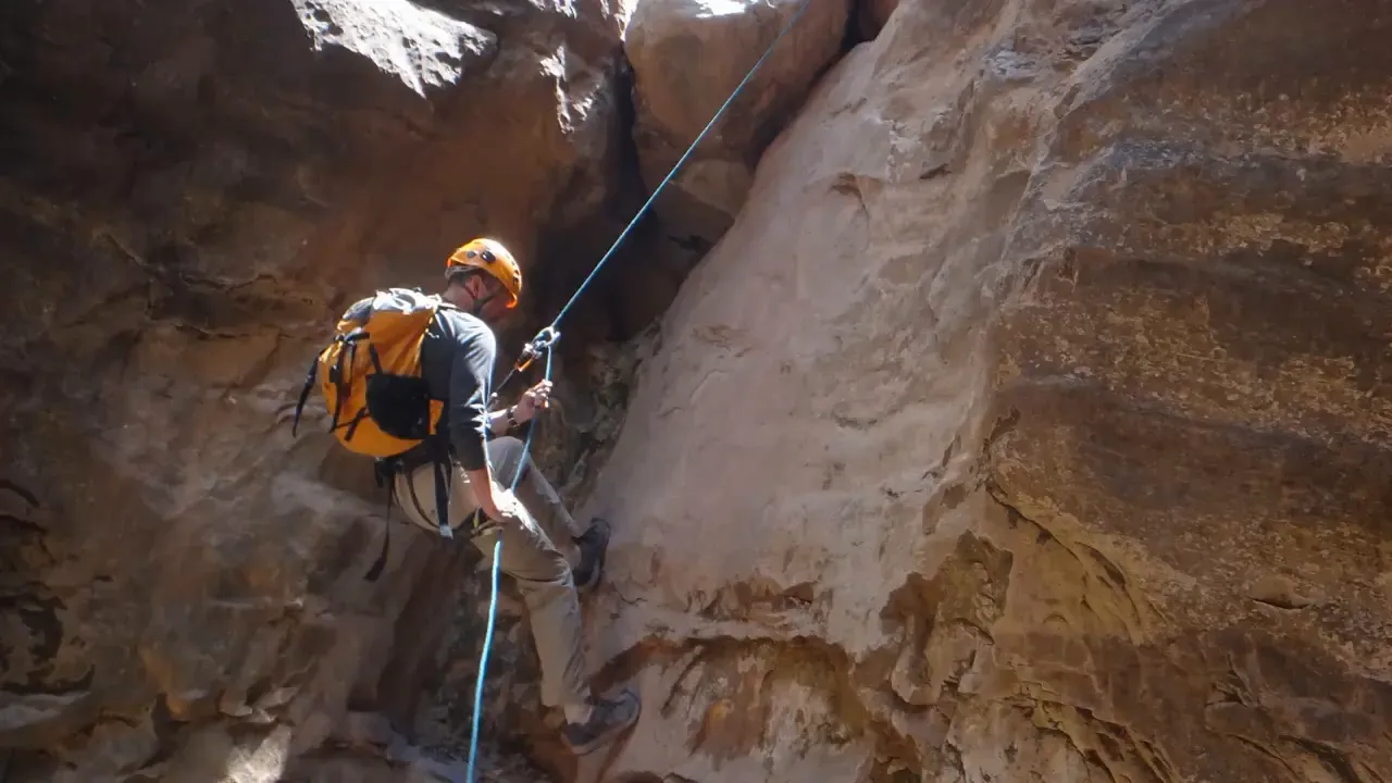 Canyoneers rappelling down a narrow slot canyon in Zion area