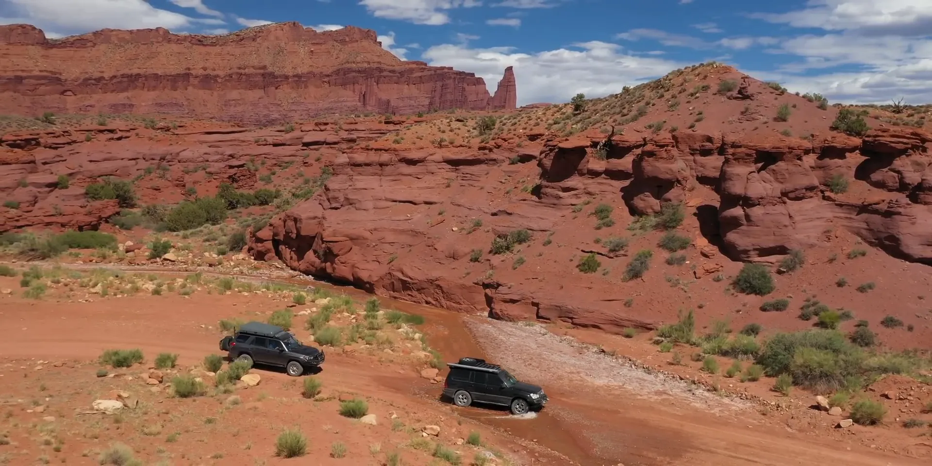 Onion Creek Road carving through steep cliffs and pillars with a shallow creek crossing
